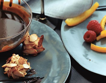 Chocolate fondue with candied orange peel, raspberries, and almond macaroons