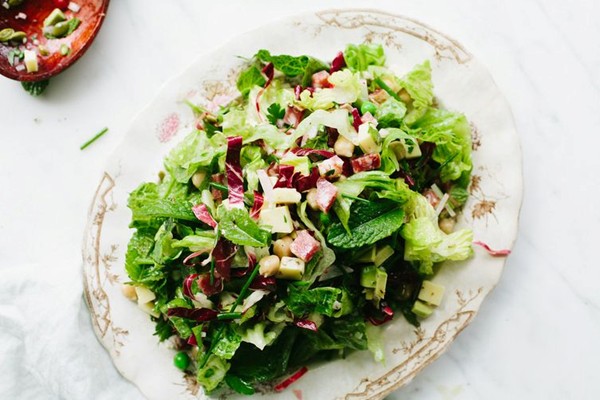 Chopped spring salad with peas, chickpeas, and salami