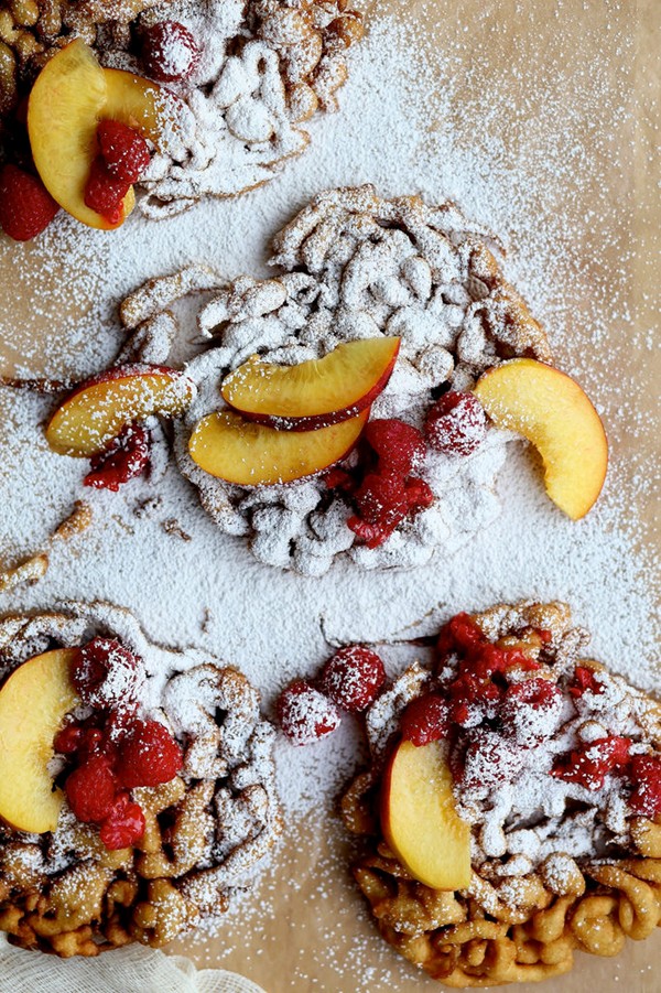 Cinnamon sugar funnel cake with peaches and raspberries