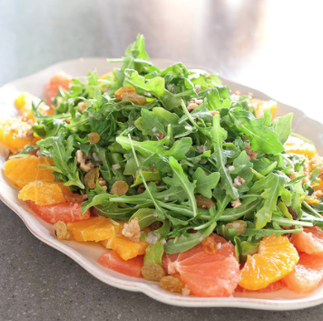 Citrus salad with arugula, golden raisins, and walnuts