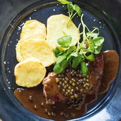 Classic French pepper steak with roasted potatoes and watercress