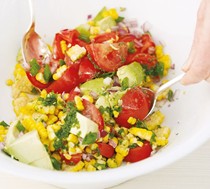 Cobb salad of corn, avocado and tomato with basil oil