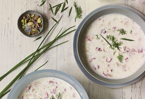 Cold yogurt soup with cucumber, herbs, and rose petals