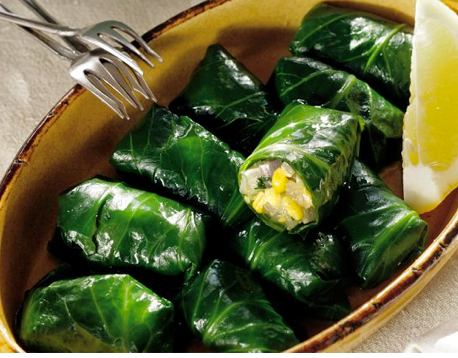 Collard green dolmades filles with dried corn and herbs (Yiaprakia)