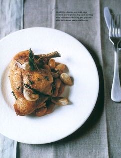 Confit chicken legs with chorizo bean stew and roasted garlic
