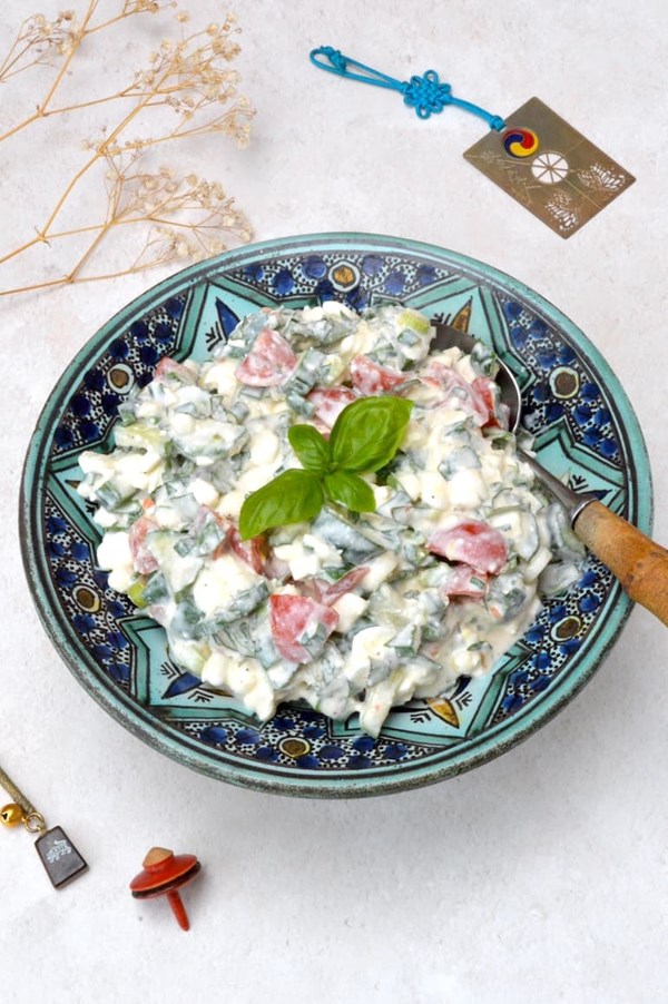 Cottage cheese salad with cucumber, tomatoes and fresh herbs