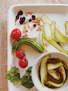 Courgette salad with minty tomato, raisins and pine nuts