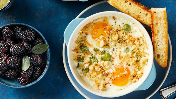 Creamy baked eggs with olives and crispy focaccia crumbs