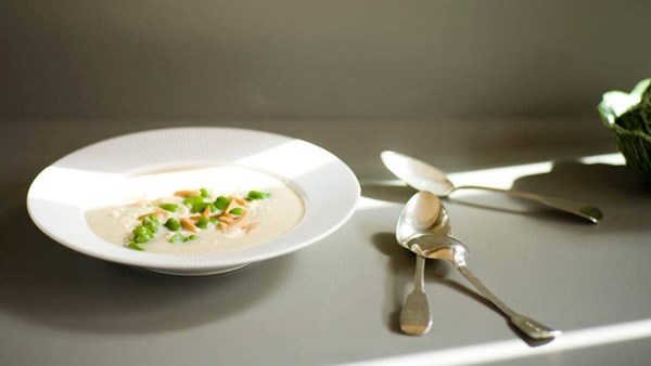 Creamy cauliflower soup with broad beans, fried almonds and feta
