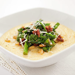 Creamy Parmesan polenta with broccoli rabe, sun-dried tomato, and pine nut topping