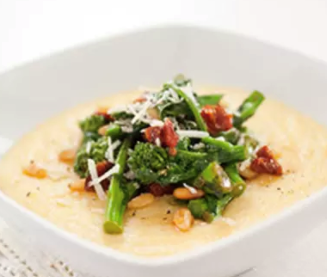 Creamy Parmesan polenta with broccoli rabe, sun-dried tomato, and pine nut topping