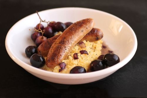 Creamy polenta with sausages and roasted grapes