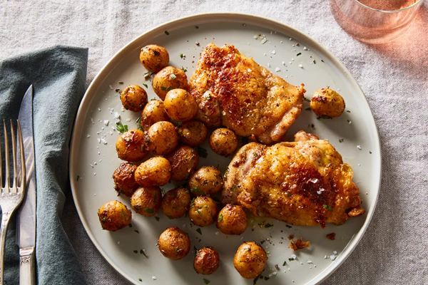 Crispy chicken thighs under a brick