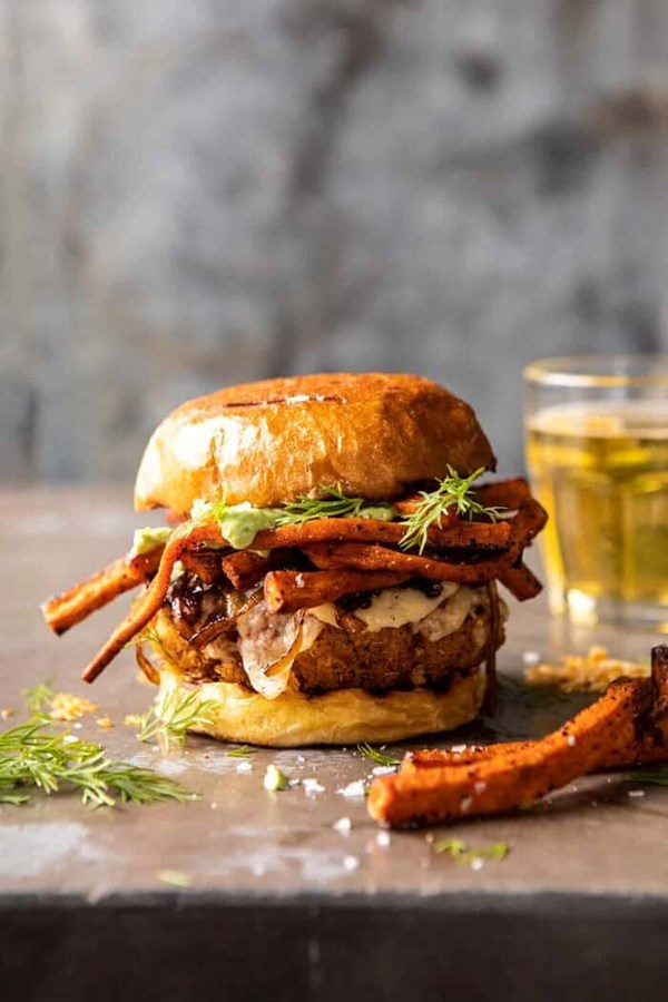 Crispy quinoa burgers topped with sweet potato fries and beer caramelized onions