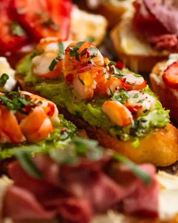 Crostini with chilli and mint prawns on Parmesan pea puree