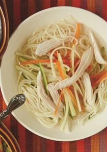 Crystal clear chicken soup with julienned vegetables and angel hair
