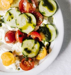 Cucumber salad with cherry tomatoes, parsley oil, and cottage cheese