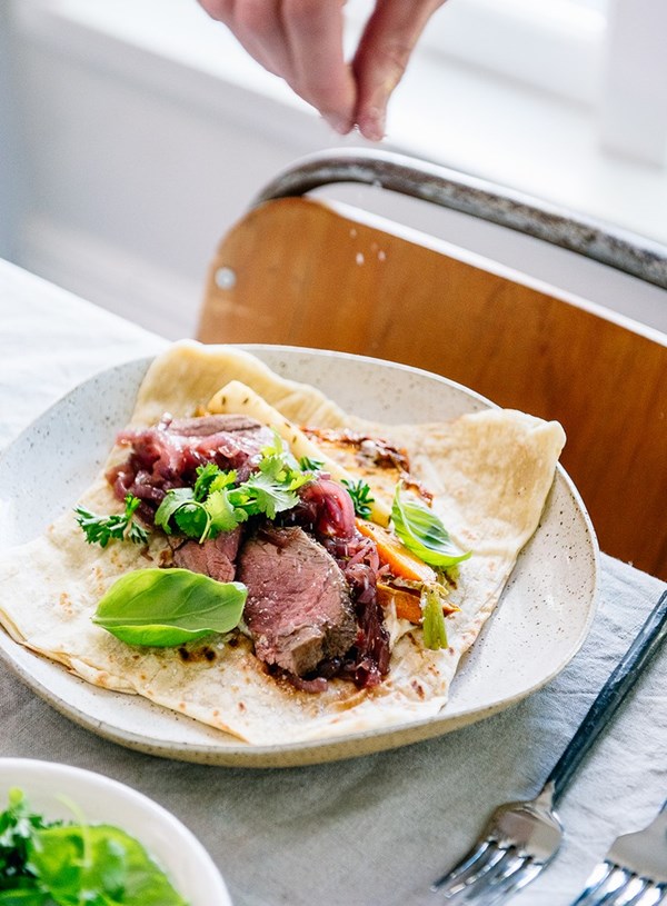 Cumin-spiced Silver Fern Farms lamb lag roast with roasted baby veges, caramelised onions and fresh herb salad