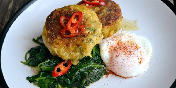Curried fish cakes with spinach and poached egg