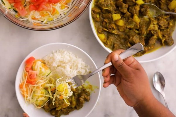 Curried goat with rice & cabbage salad