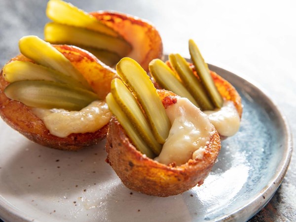 Deep-fried potato skins with melted raclette cheese