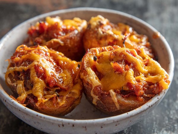 Deep-fried potato skins with pulled pork and cheddar