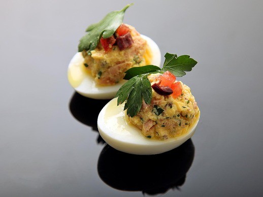 Deviled eggs with confit tuna, olives, tomato, and olive oil