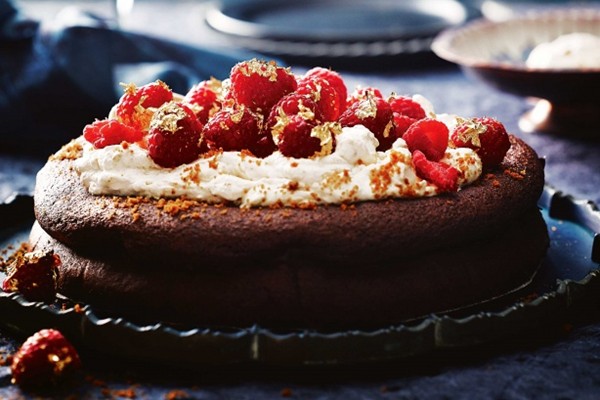 Drunken, sunken chocolate cake with spiced cookie cream and gilded raspberries