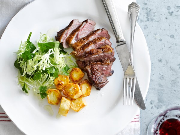 Duck breasts with crispy potatoes and frisée salad