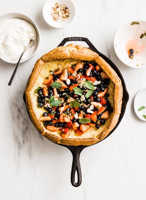 Dutch baby with almonds, fresh berries, mint and mascarpone whipped cream