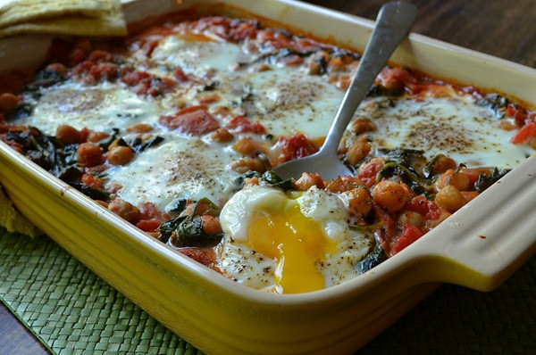 Eggs baked in chickpea-tomato sauce with baby spinach