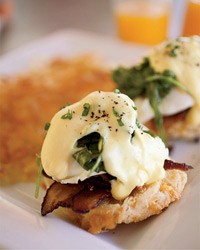 Eggs Benedict with bacon and arugula