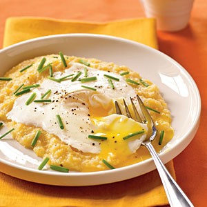 Eggs blindfolded over garlic-cheddar grits