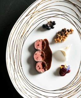 Fallow venison loin with walnut crumble, seasonal vegetables, and sauce salmis