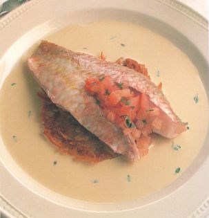 Fillet of red mullet baked with braised onion, tomato and thyme and served on a rosti potato with a cream sauce