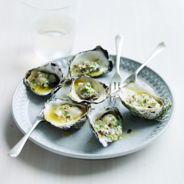 Fire-grilled oysters with green garlic & pastis butter [John Besh]