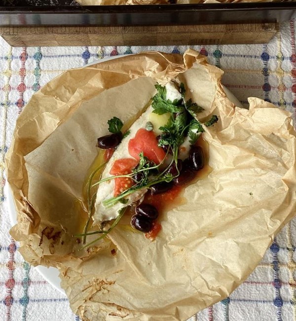 Fish baked al cartoccio with tomatoes, olives and capers