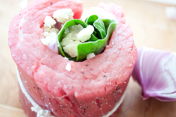 Flank steak stuffed with blue cheese and spinach with creamy horseradish sauce