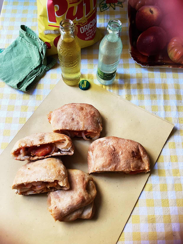 Folded flatbreads with tomato, onion and cheese (scacce)