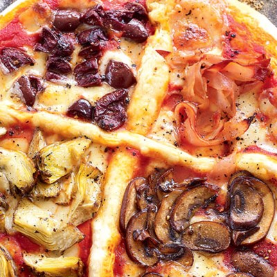 Four seasons pizza topped with ham, artichokes, mushrooms and olives (Quattro stagioni)