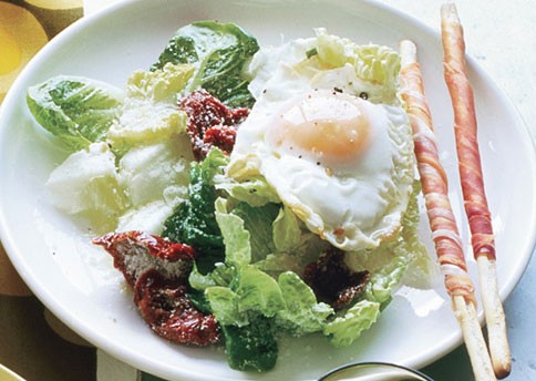 Fried-egg Caesar with sun-dried tomatoes and prosciutto breadsticks