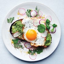 Fried eggs on toast with salted herb butter and radishes