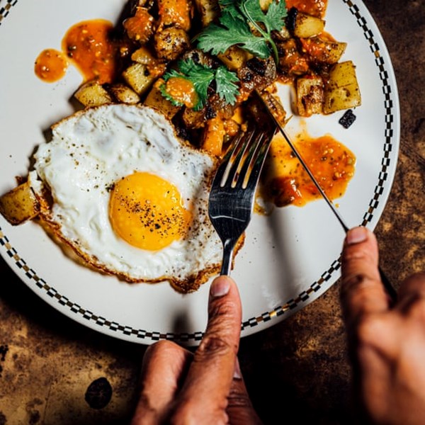 Fried eggs with masala hash browns and seared tomato green peppercorn chutney