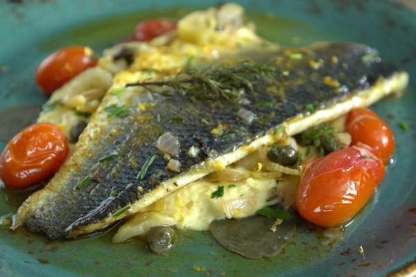 Greek sea bass baked with Santorini assyrtiko wine, caper leaves, and herbs (Lavraki me kaparofylla kai assyrtiko Santorinis)