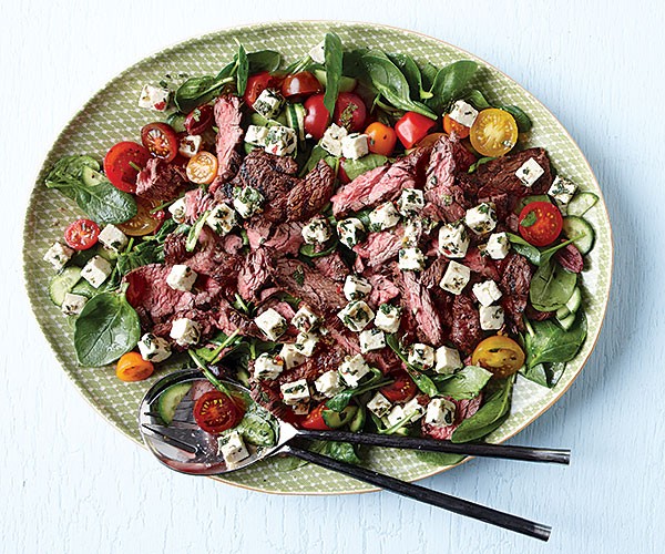 Greek spinach salad with grilled flap steak and marinated feta
