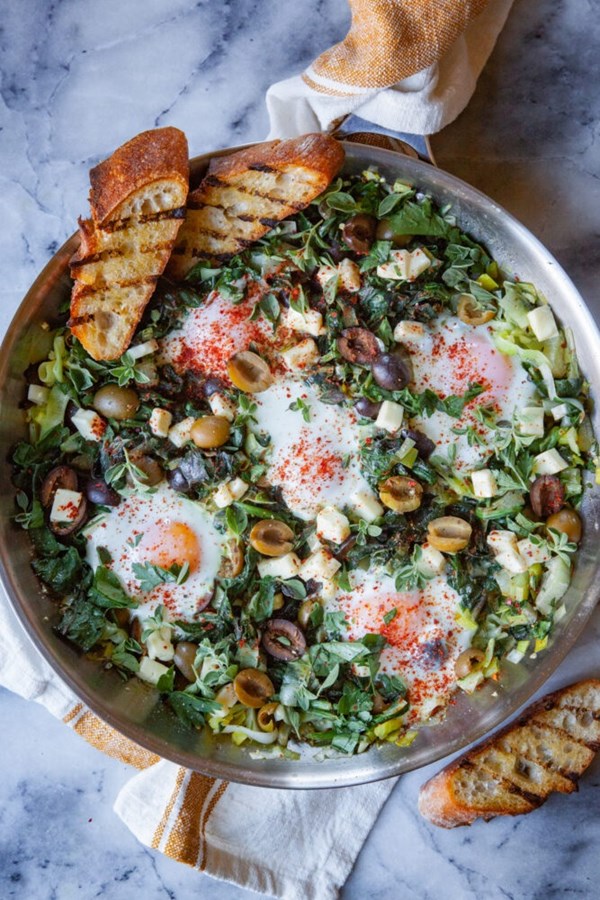 Green shakshuka with green and black ripe olives