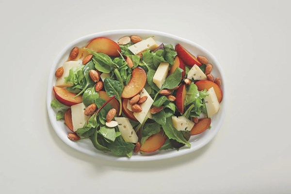 Greens with fruit, cheese, and nuts