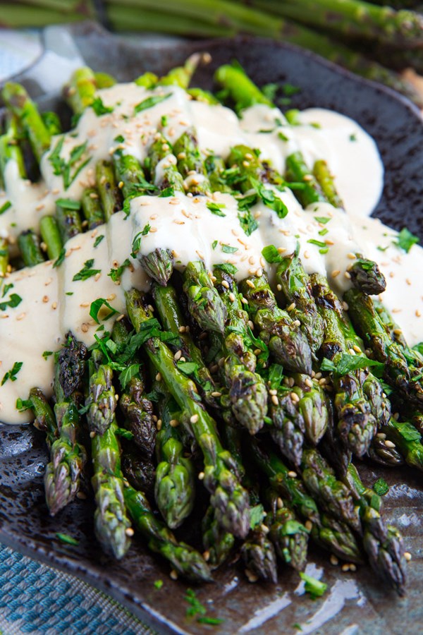 Grilled asparagus in lemon maple tahini with tomatoes and cucumbers