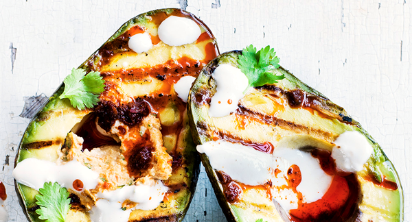 Grilled avocado halves with harissa hummus and tahini yogurt