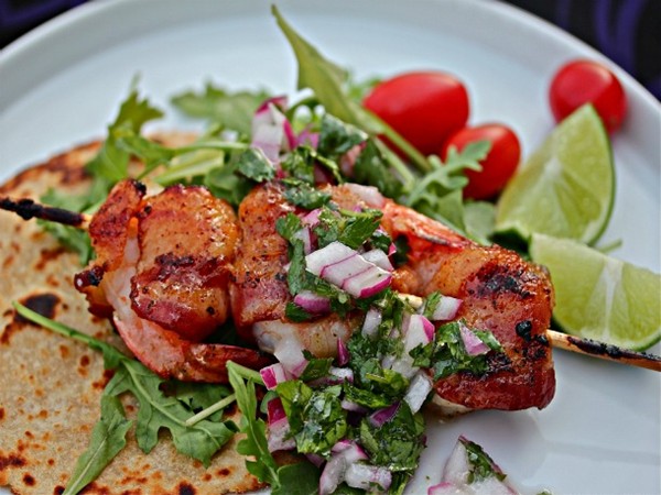 Grilled, bacon-wrapped shrimp with arugula and red onion relish